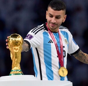 Ángel Correa tocando la Copa Mundial de la FIFA ganada en Qatar 2022.
