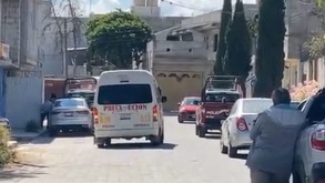 Vecinos observan a lo lejos una vivienda donde un hombre se quitó la vida en el municipio de Tehuacán, Puebla.