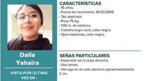 Se observa a una joven con lentes y unos aretes grandes color plateados, ella está sonriendo.