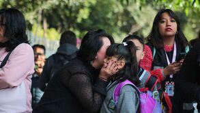 Estudiante de educación básica se despide de su madre, antes de entrar a clases, en Puebla.
