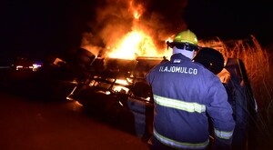 Bombero de Tlajomulco de visto de espaldas mientras controlaba el incendio de una pipa en carretera Guadalajara-Colima durante la noche