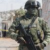 Una persona con vestimenta militar y un arma resguarda la zona de un crimen en Puebla.