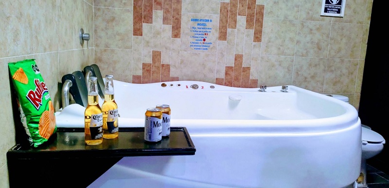 Cervezas y botana junto a una tina de baño instalada en un motel de Atlixco, Puebla.