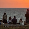 Personas juntas para ver una puesta de sol desde una playa en México.