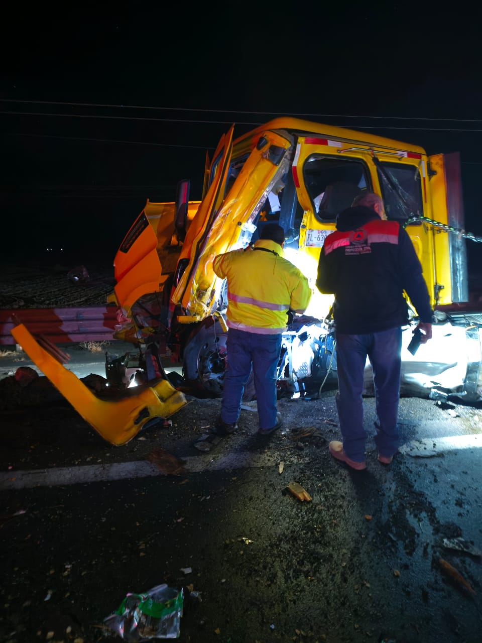 Tráiler amarillo destruido tras un choque entre dos vehículos.