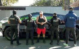 Hombre detenido con elementos de la policía a ambos lados