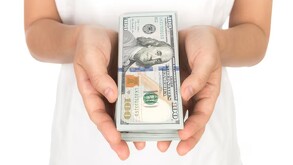 Mano sosteniendo dólares estadounidenses.