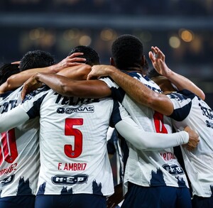 Jugadores de Rayados abrazados tras la segunda anotación.
