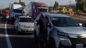Una persona mira un accidente de tránsito desde fuera de su vehículo.
