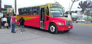 Se observa un camión rojo con amarillo y unas personas que están paradas.