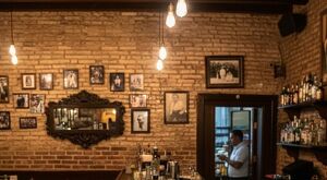 En la imagen se observan bebidas embriagantes en una barra, y al fondo un hombre.