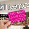 Aspecto de una tienda Liverpool en México, con una mano sobrepuesta cargando una tarjeta de la tienda.