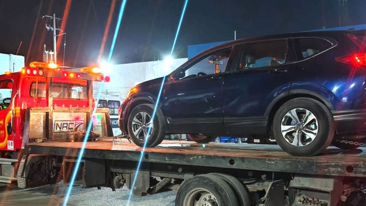 Camioneta en color azul arriba de una grúa
