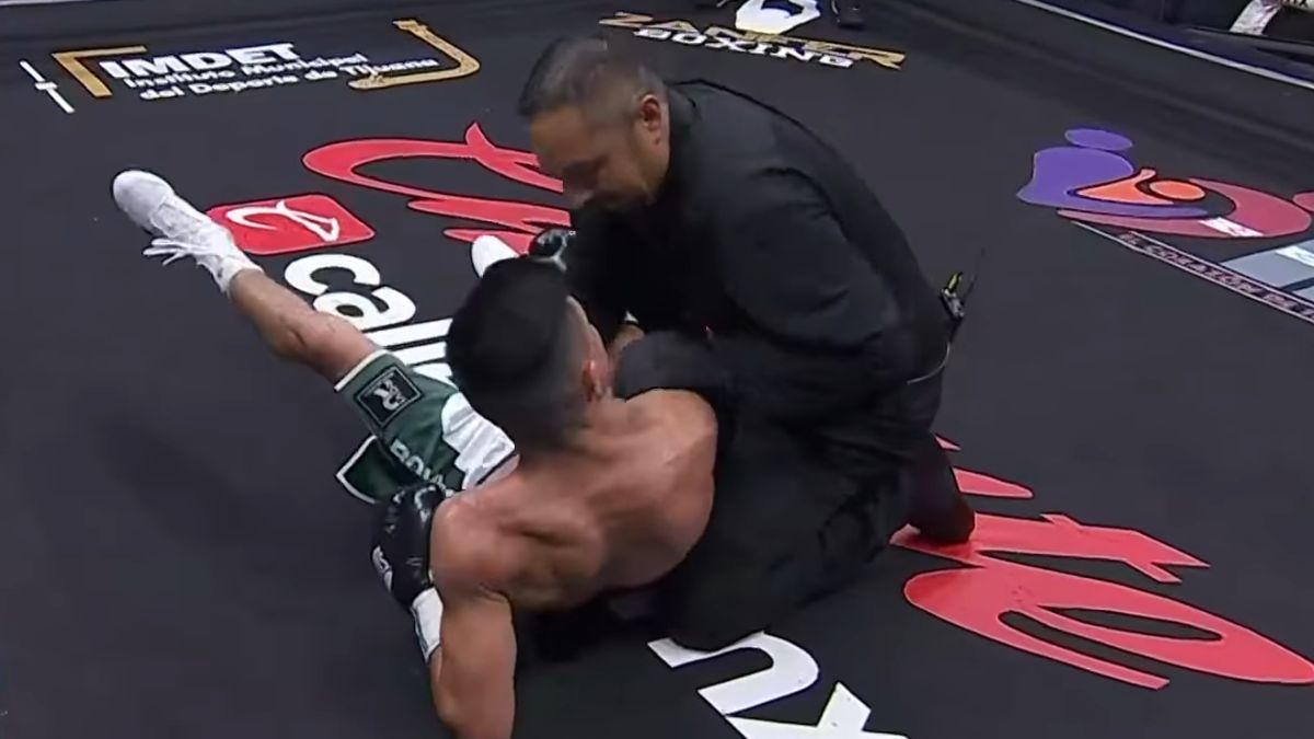 Argi Cortés en la lona tras un gancho de Yahir Frank, mientras el réferi lo revisa.