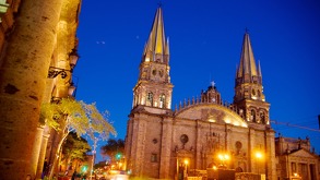 Vista de la Rotonda de los Jaliscienses Ilustres en Guadalajara; al fondo sobresale una de las icónicas torres amarillas de la Catedral Basílica.