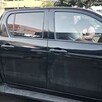 Conductor con playera blanca dormido al interior de una camioneta negra con la puerta abierta estacionada sobre la Avenida Ávila Camacho en Guadalajara