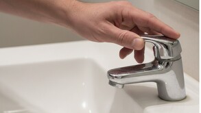 Mano abre llave de un lavamanos y no sale agua