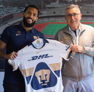 Juninho Vieira cargando la camisa de Pumas junto a Luis Raúl González, presidente de Pumas.