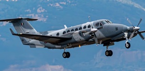 Avión de la Marina de México sobrevolando un terreno montañoso.