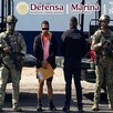 Armando 'G', alias 'Delta 1', en medio de militares del Ejército Mexicano y la Guardia Nacional, con los ojos censurados  y sosteniendo un sobre amarillo