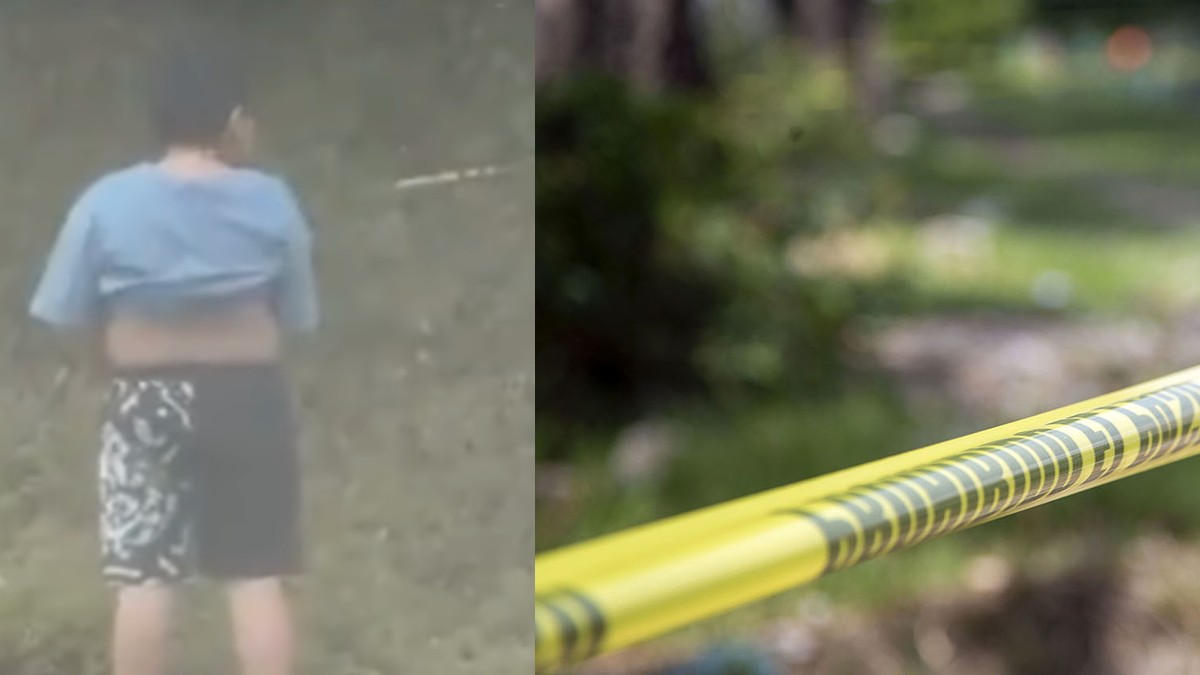 Niño cpn playera azul y short parado en plena carretera