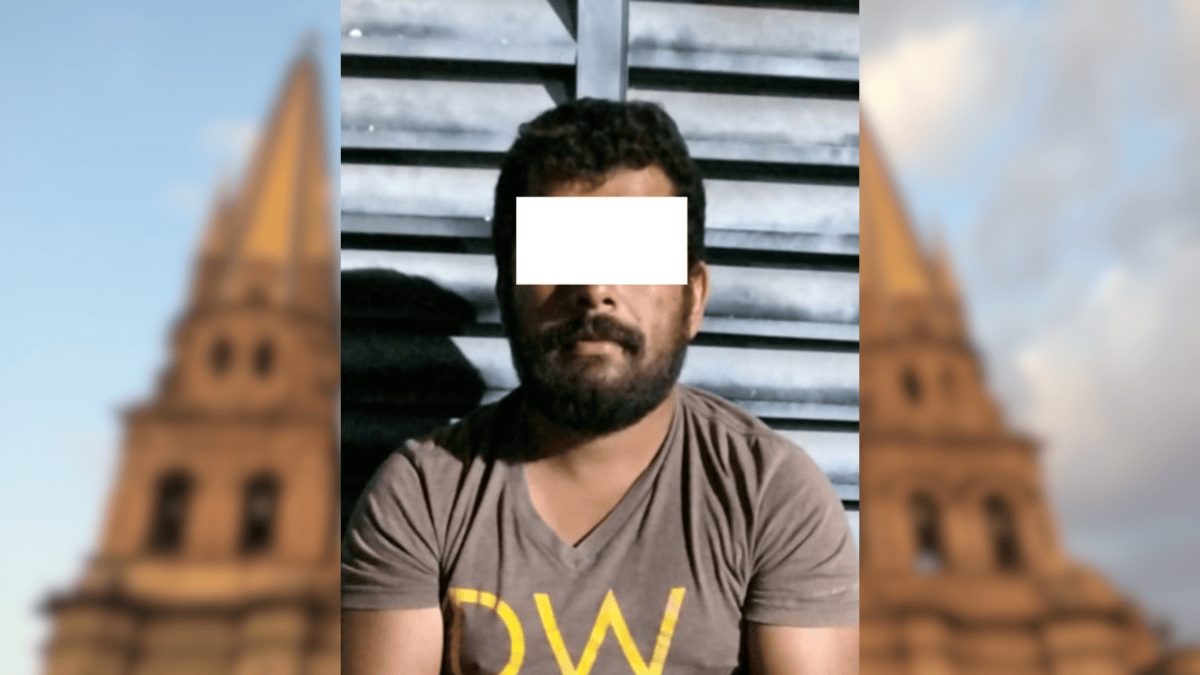 Un mono araña pequeño con arnés es sostenido por una persona en una plaza pública; al fondo se aprecian las torres de la Catedral de Guadalajara.