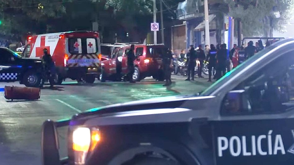 Ambulancia de Guadalajara al lado de una camioneta roja y una patrulla de Guadalajara con personas y policías alrededor