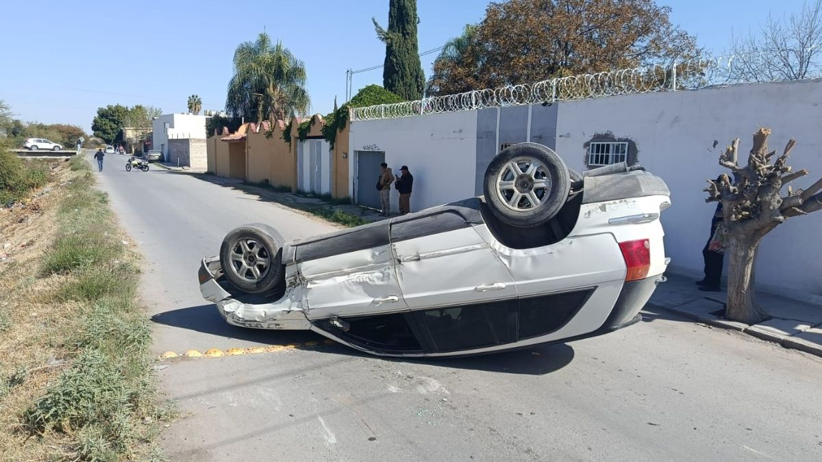 Auto blanco volcado en Gómez Palacio, de día y un cielo azul.