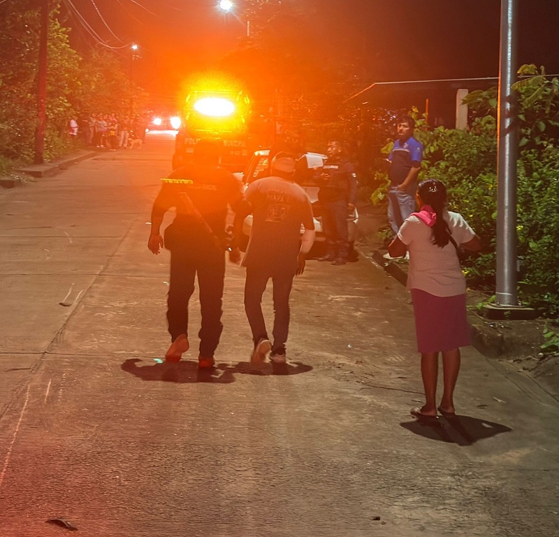 Un policía caminando junto a un hombre con vendajes.