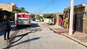 Bomberos atendiendo el incendio en una vivienda del fraccionamiento Filadelfia de Gómez Palacio.