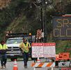 Se observa a equipos de trabajo en un cierre vial en la Ruta Estatal 27 y la Carretera de la Costa del Pacífico debido a las fuertes tormentas en California.