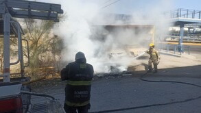 Elementos de Bomberos controlando la quema de maleza frente a un yonke en Gómez Palacio.