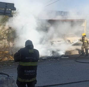 Elementos de Bomberos controlando la quema de maleza frente a un yonke en Gómez Palacio.