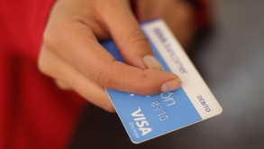 Una mano humana sosteniendo una tarjeta de banco.