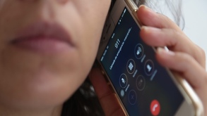 Una mujer utiliza su teléfono celular para marcar al número de emergencias 911.