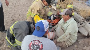 Hombre siendo atendido por paramédicos tras ser aplastado por un tractocamión
