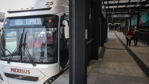 Mexibús arribando a una estación en fiestas de fin de año.