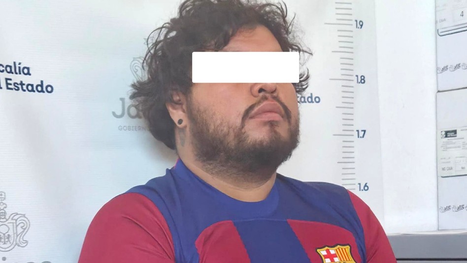 Joven de cabello rizado, barba y un piercing viendo hacia el frente con los ojos censurados en la Fiscalía de Jalisco