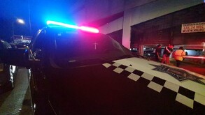 Patrulla de la Policía Municipal de Guadalajara estacionada a las afueras de un con la sirena encendida.