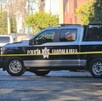 Vista lateral de una Patrulla de la Policía Municipal de Guadalajara estacionada sobre la calle y detrás de una cinta policiaca