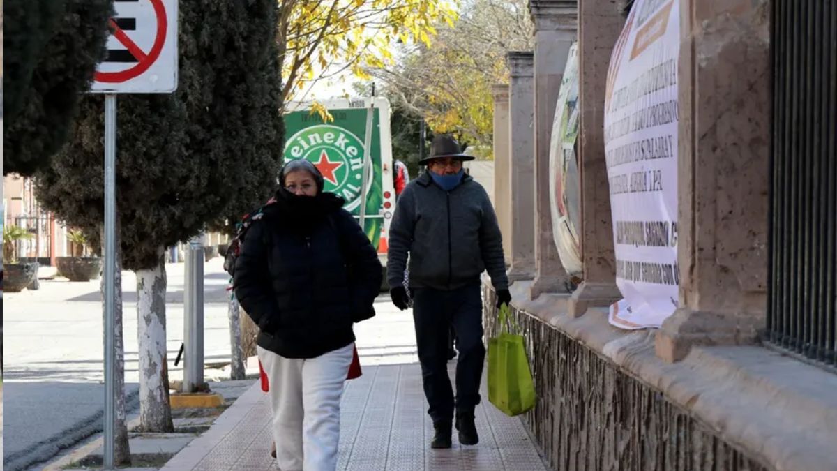 Personas adultas caminando con frío en las calles de Torreón.