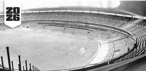 Una fotografía en blanco y negro de las gradas vacías de un gran estadio de fútbol, con un logotipo en la esquina que indica el año 