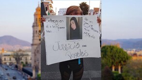 Una persona sostiene una pancarta que dice 