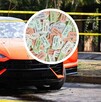 Un auto deportivo naranja con impactos de bala en el parabrisas está acordonado; un círculo superpuesto muestra boletos de rifa de colores.