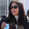 Una mujer con gafas oscuras hablando frente a una cámara.
