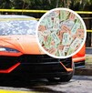 Un auto deportivo naranja con impactos de bala en el parabrisas está acordonado; un círculo superpuesto muestra boletos de rifa de colores.