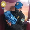 una mujer policía carga a una bebé tras asistir un parto en la tapo cdmx