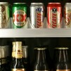 Se observan varias latas de cerveza dentro de un refrigerador.