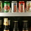 Se observan varias latas de cerveza dentro de un refrigerador.