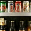 Se observan varias latas de cerveza dentro de un refrigerador.
